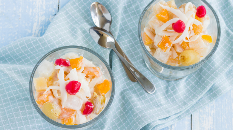Cream cheese fruit salad in two glasses with spoons