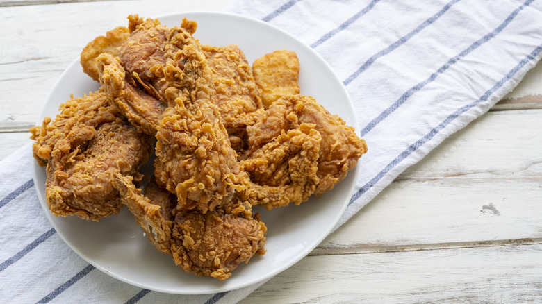 Fried chicken on a plate on top of a striped dish towel.