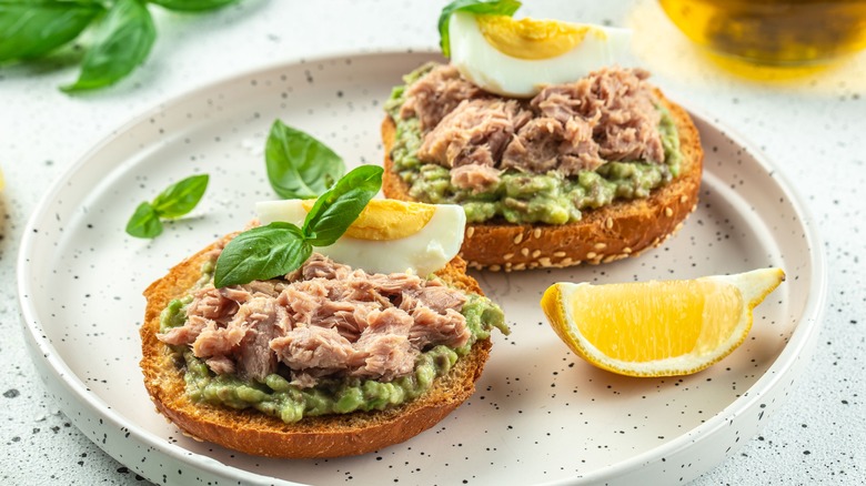 A sandwich with canned tuna, egg, and avocado.