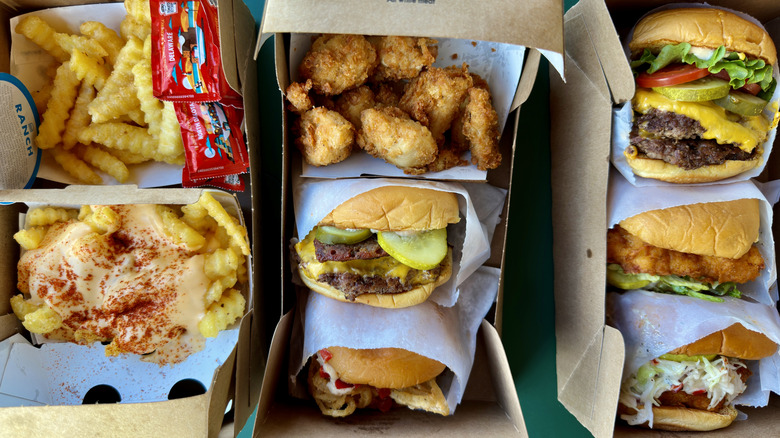 Close up of several burgers, chicken sandwiches, fries, and chicken nuggets from Shake Shack