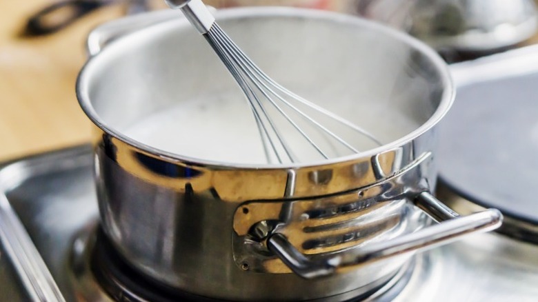 Milk being whisked in a pot 