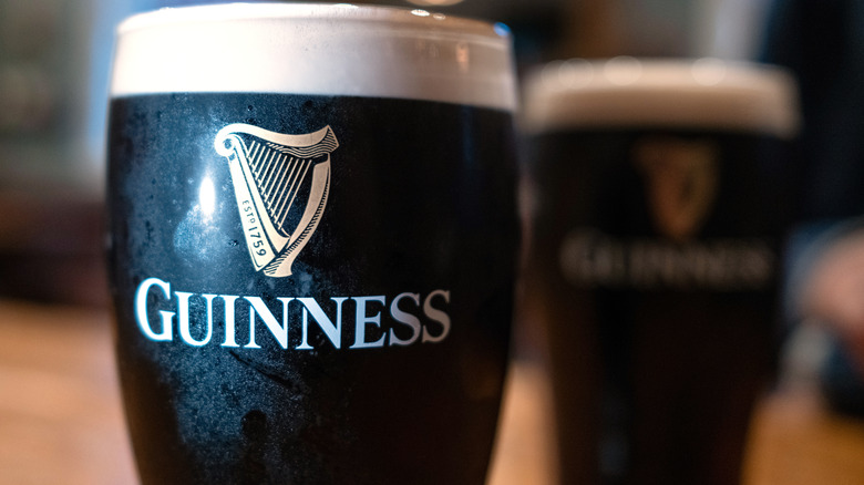 A closeup of two pints of Guinness at a bar