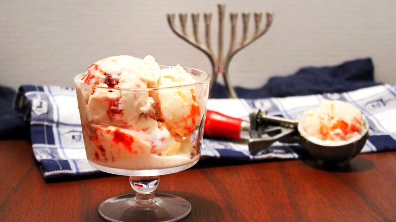 Ice cream in a glass bowl in front of Jewish menorah