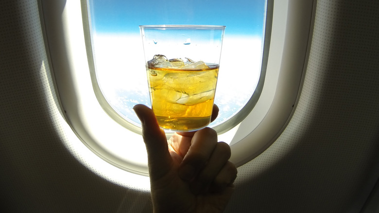 Holding a beverage full of ice on an airplane