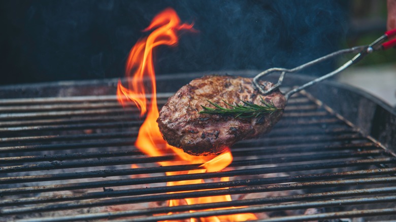 Steak being finished over grill flame