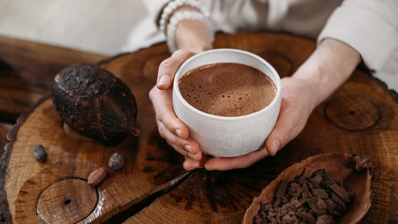 person holding hot chocolate over wooden table