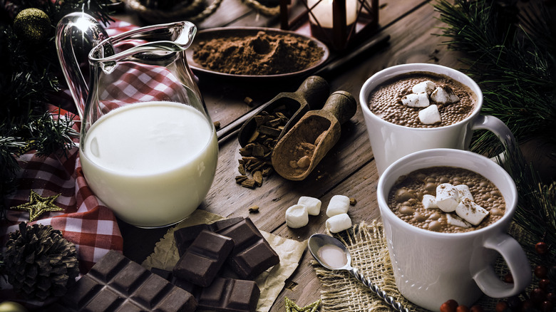 mugs of hot chocolate with milk on table