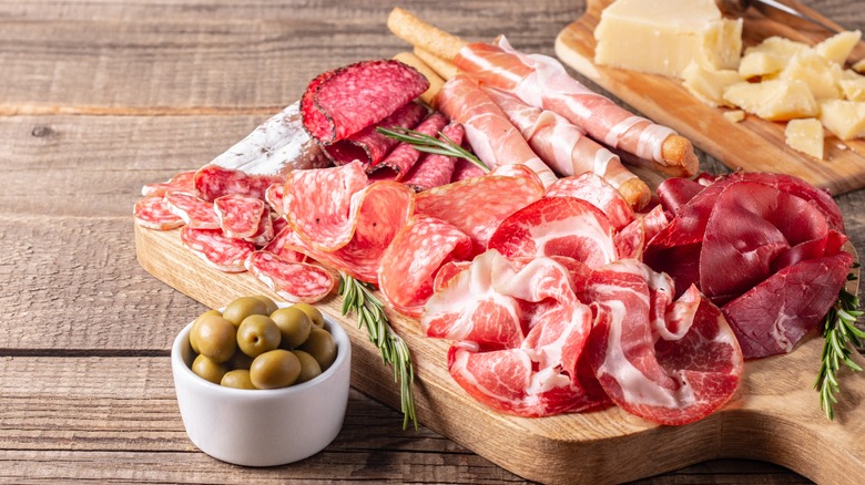 Charcuterie board. Antipasti appetizers of meat platter with salami, prosciutto crudo or jamon and olives.