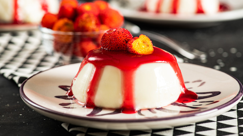 Creamy panna cotta topped with berries and fruit sauce