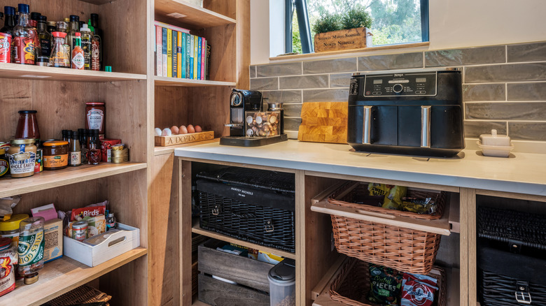 Cans and jars sit in a pantry away from kitchen appliances