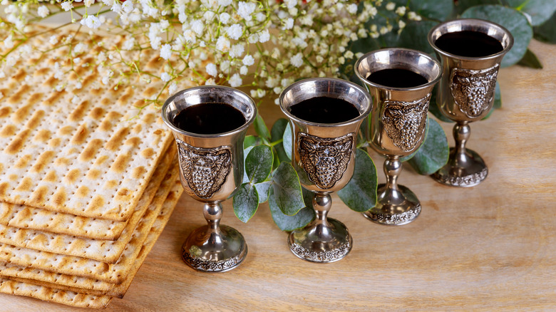 Four cups of wine next to matzoh