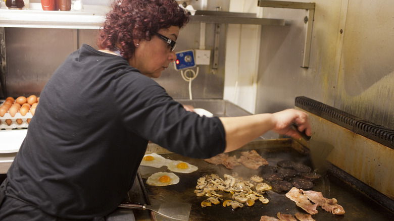 Woman making breakfast in restaurant