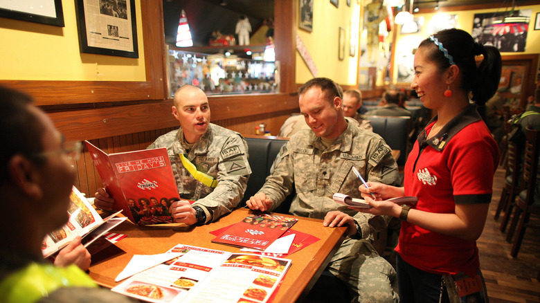 Two customers in military uniforms ordering food at TGI Friday's.