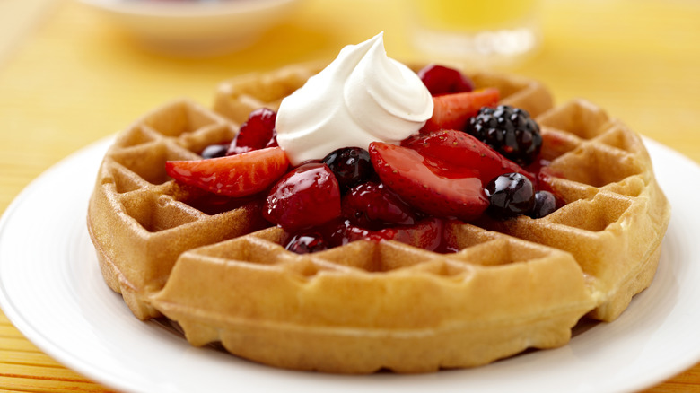 Fresh waffle with berries and whipped cream