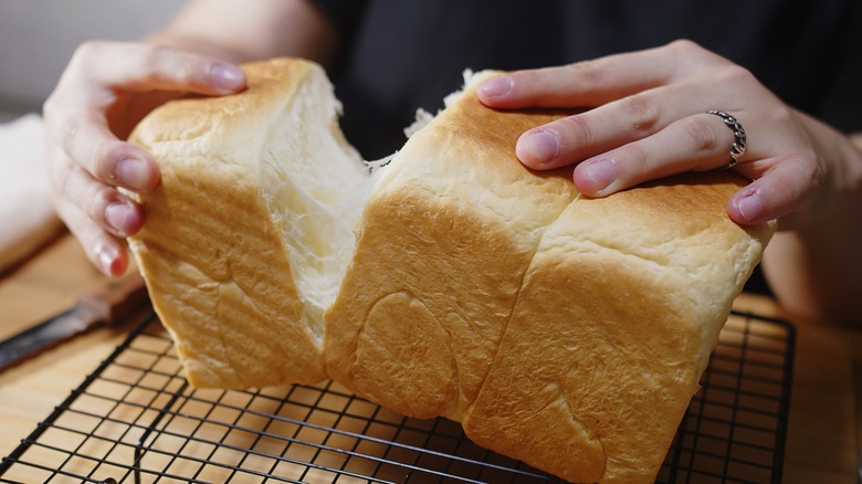 Hands pulling milk bread apart
