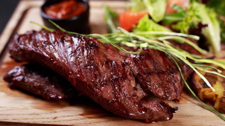 sliced medium rare steak on a wooden plank