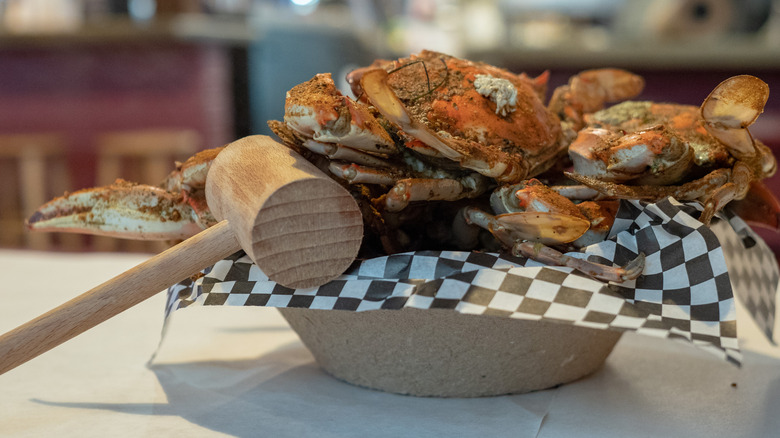 Basket of cooked blue crabs and mallet
