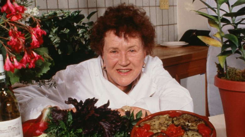 Julia Child surrounded by produce and pans