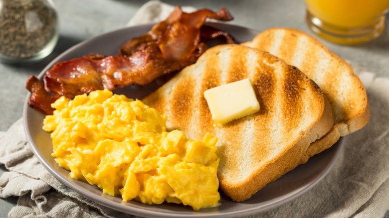 Breakfast with scrambled eggs, bacon, and toast