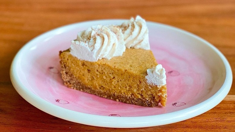 Slice of fluffy bourbon pumpkin pie with whipped cream