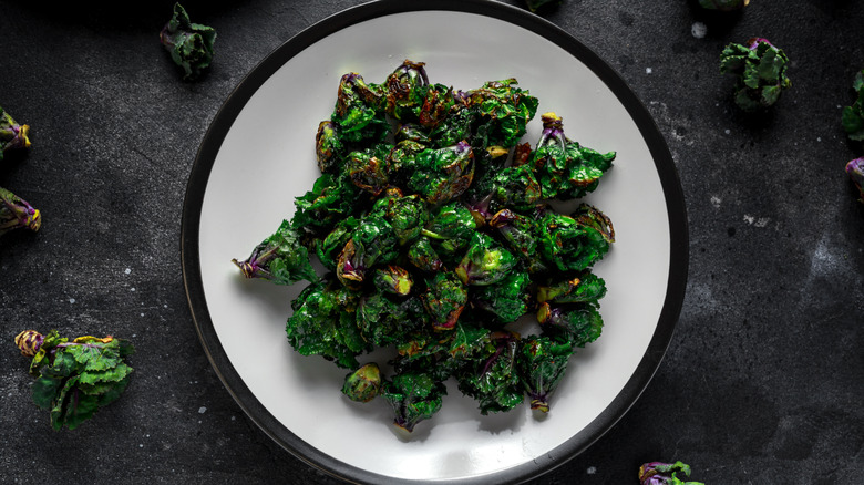 A plate of sauteed kalettes is surrounded by loose kalettes