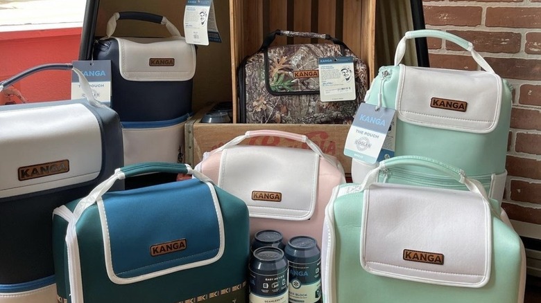 Several Kanga Coolers in colors including mint green, pink, and camouflage print grouped together