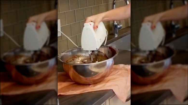 mixing batter in bowl over damp towel