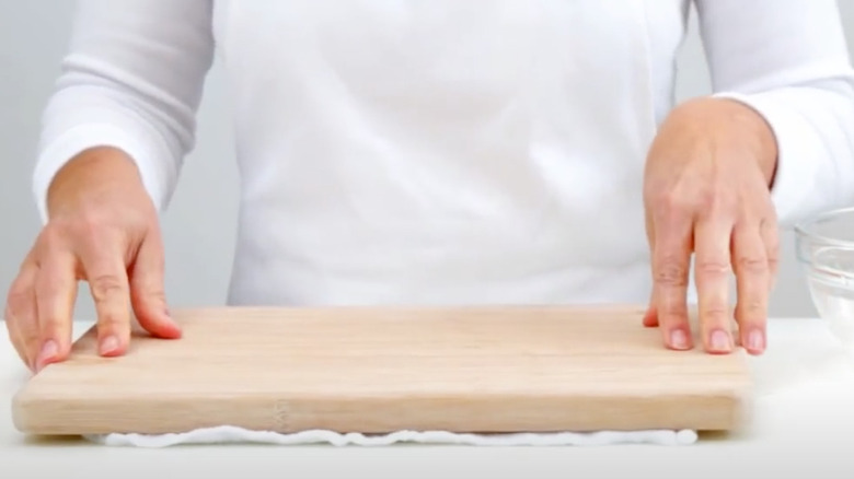 damp towel placed under cutting board