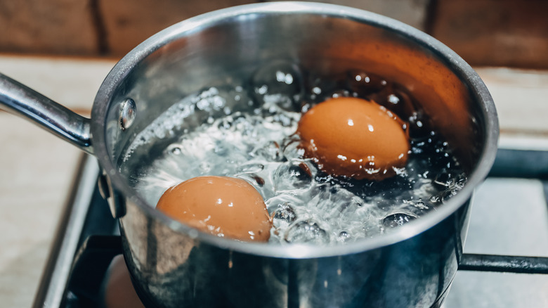 Two eggs boiling in a pot
