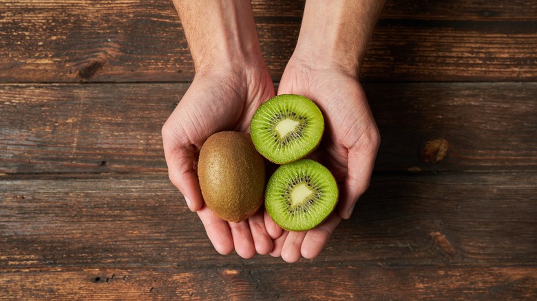 Person holding kiwi in hands