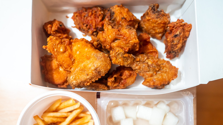 Korean fried chicken set in paper box with fries and pickled radish