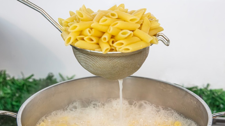 colander removing pasta from pot