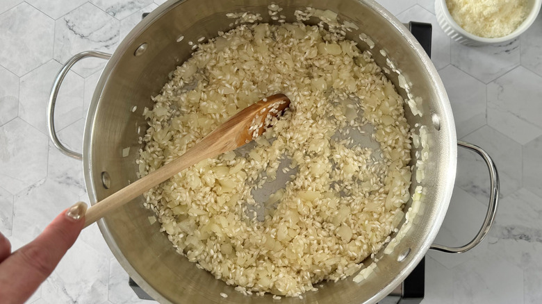 stirring rice to coat with onions and garlic