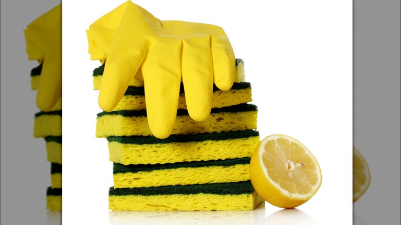 Pile of sponges, dish glove and lemon half