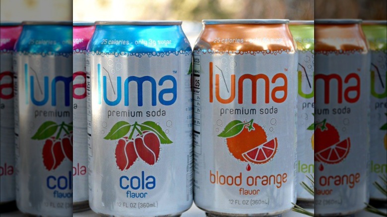 glass of blood orange luma soda and can of it