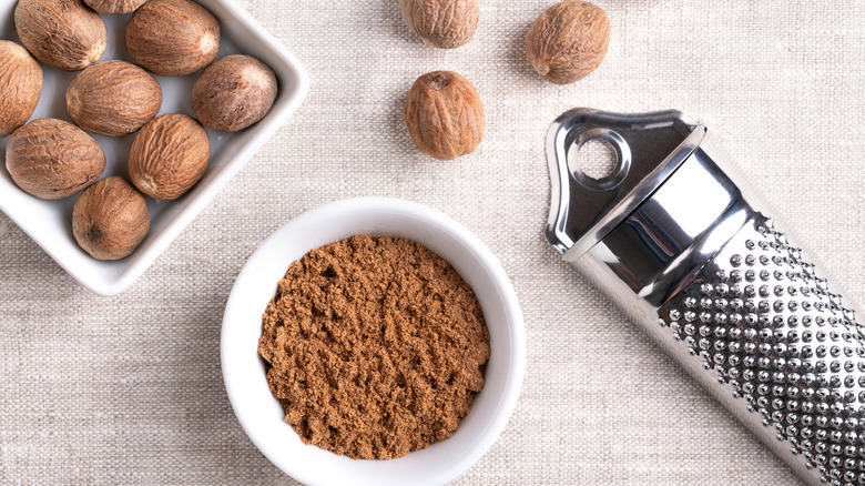 Nutmeg powder, whole seeds, and a spice grater