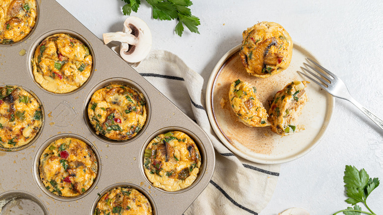 Plate with mushroom egg bites next to a muffin baking tray with egg bites inside