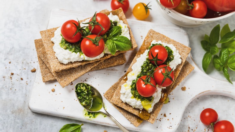 Crackers with cottage cheese, pesto, basil and pesto.