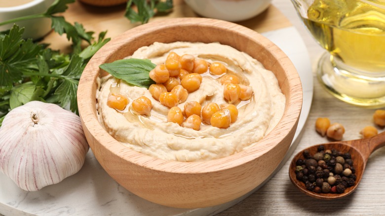 Bowl of hummus surrounded by ingredients