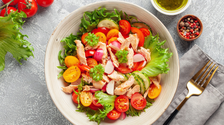 A big chicken and tomato salad in a bowl