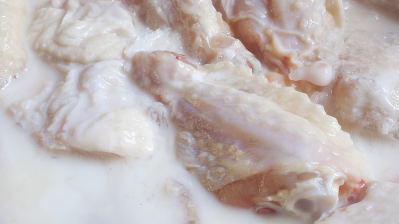 raw chicken marinating in buttermilk