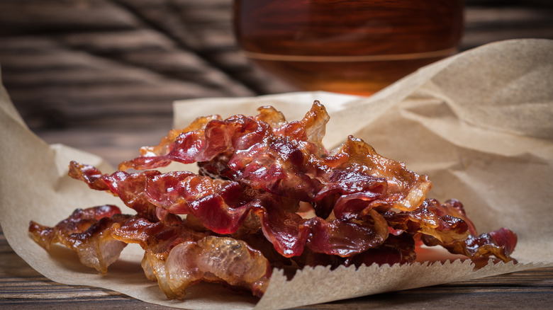 Cooked bacon with glass of whiskey