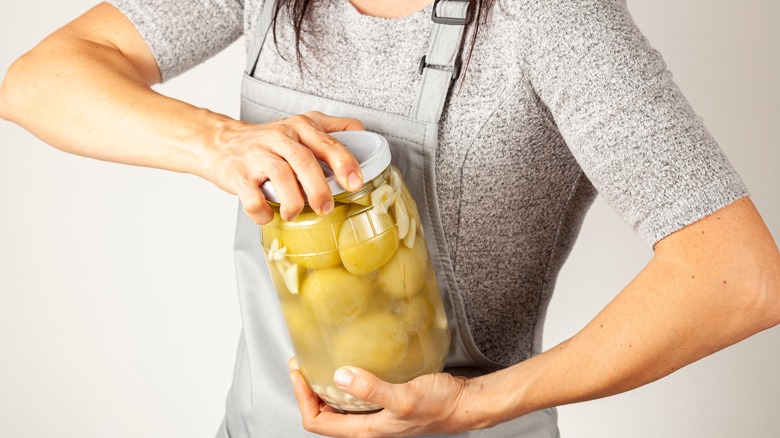 Person trying to open tight jar lid