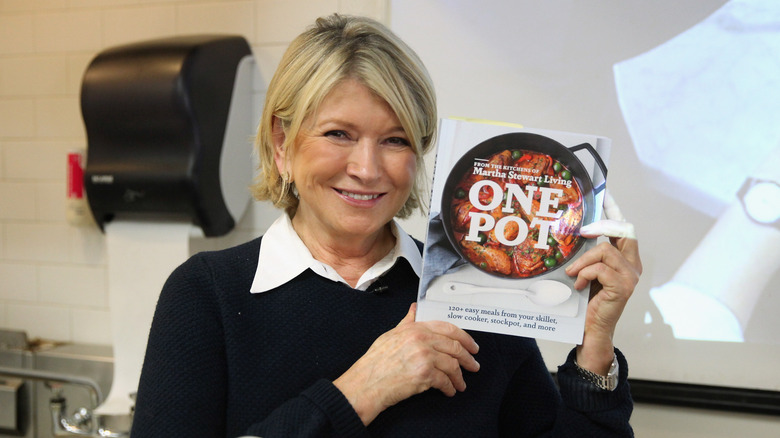 Martha Stewart holding a cookbook