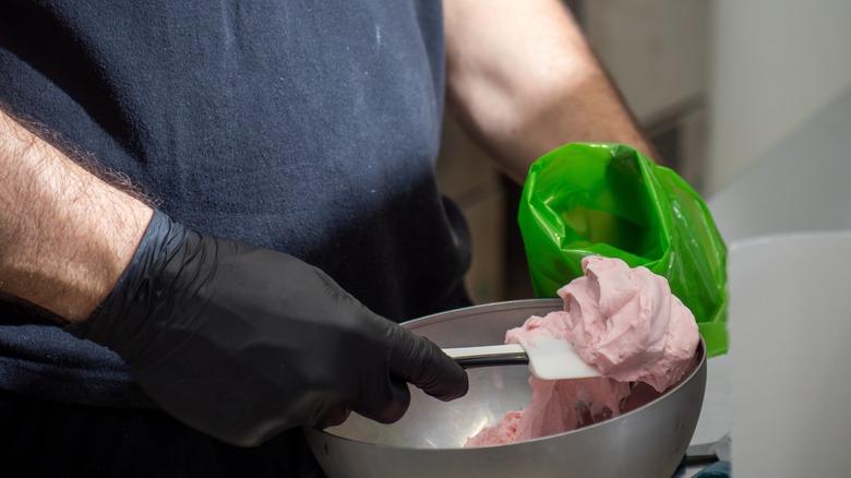 Person loading piping bag with frosting