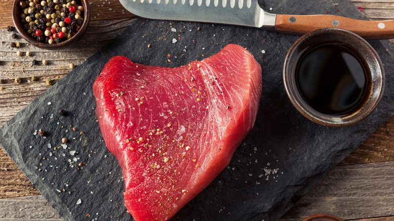 Raw tuna steak on cutting board