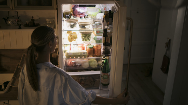 woman looking inside a refrigerator