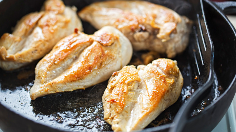 chicken breasts browning in saute pan