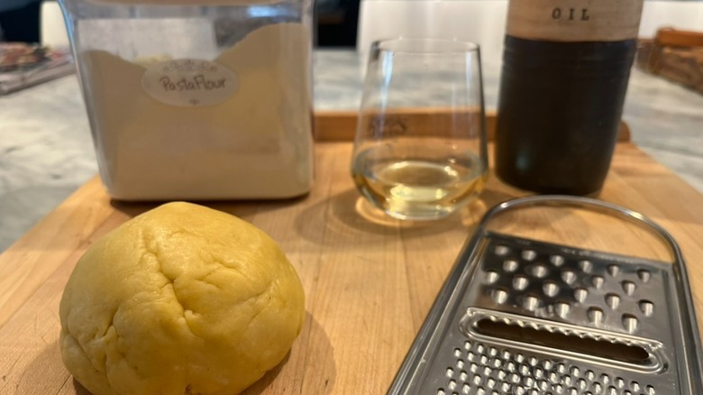 egg pasta dough with cheese grater and grattini ingredients