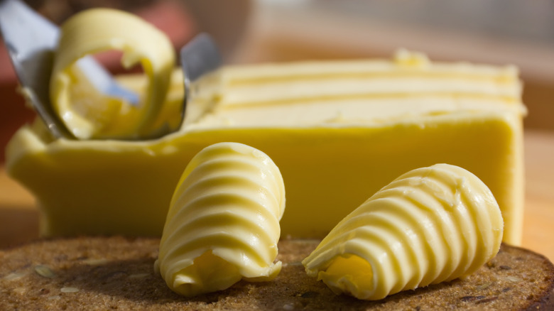 Shaved curls of butter near a block of butter